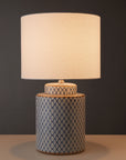 Blue and white ceramic table lamp with white shade lit