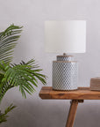 Blue and white ceramic table lamp with white shade on wooden console