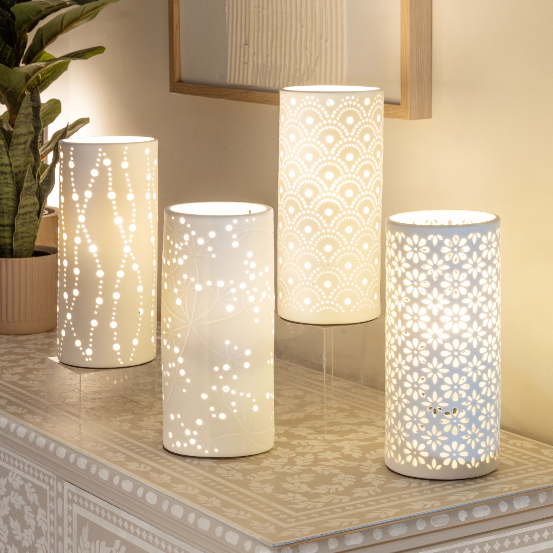 Four porcelian table lamps lit on a small buffet